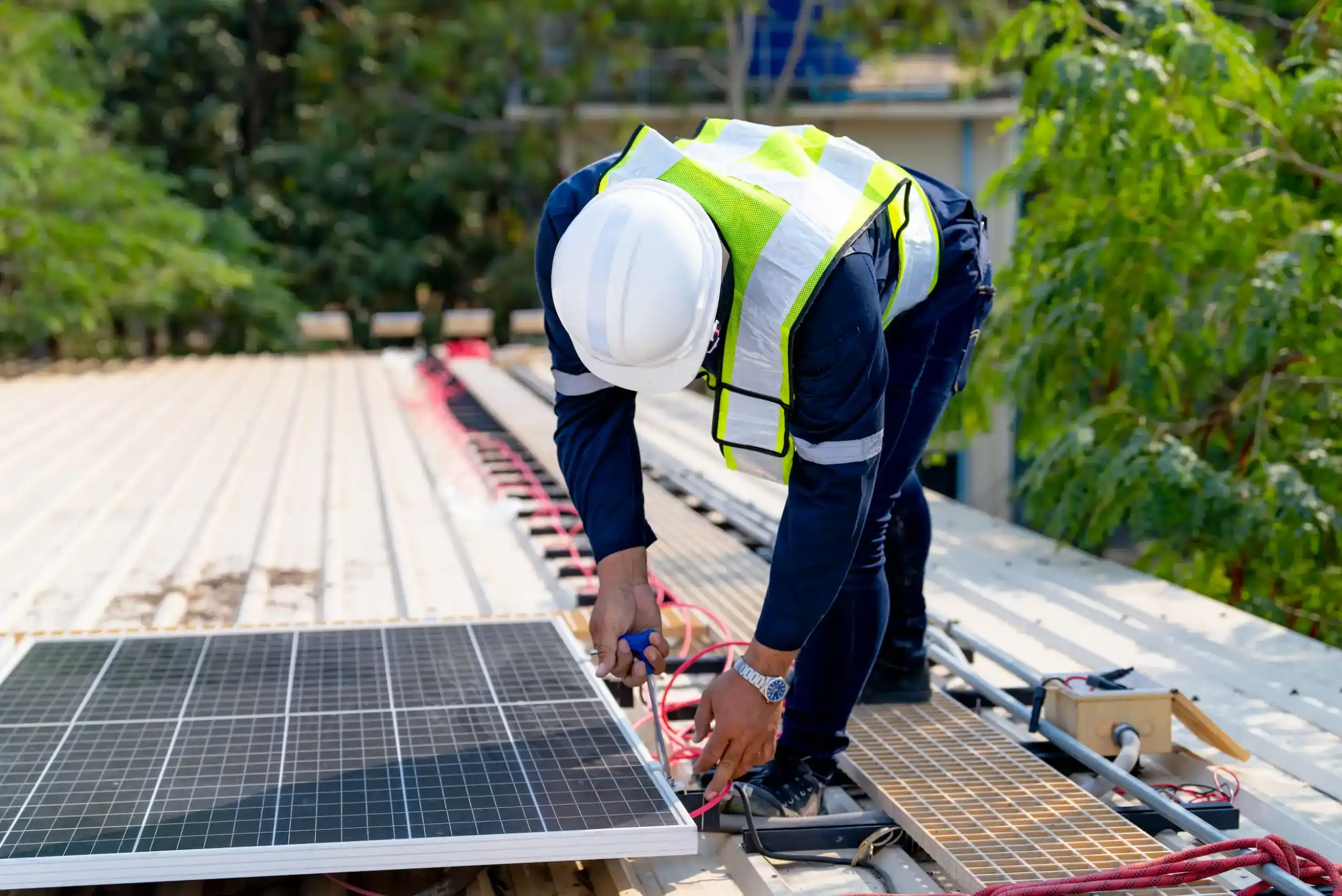 Electrician wiring a solar panel on a residential rooftop during installation in Rockhampton.