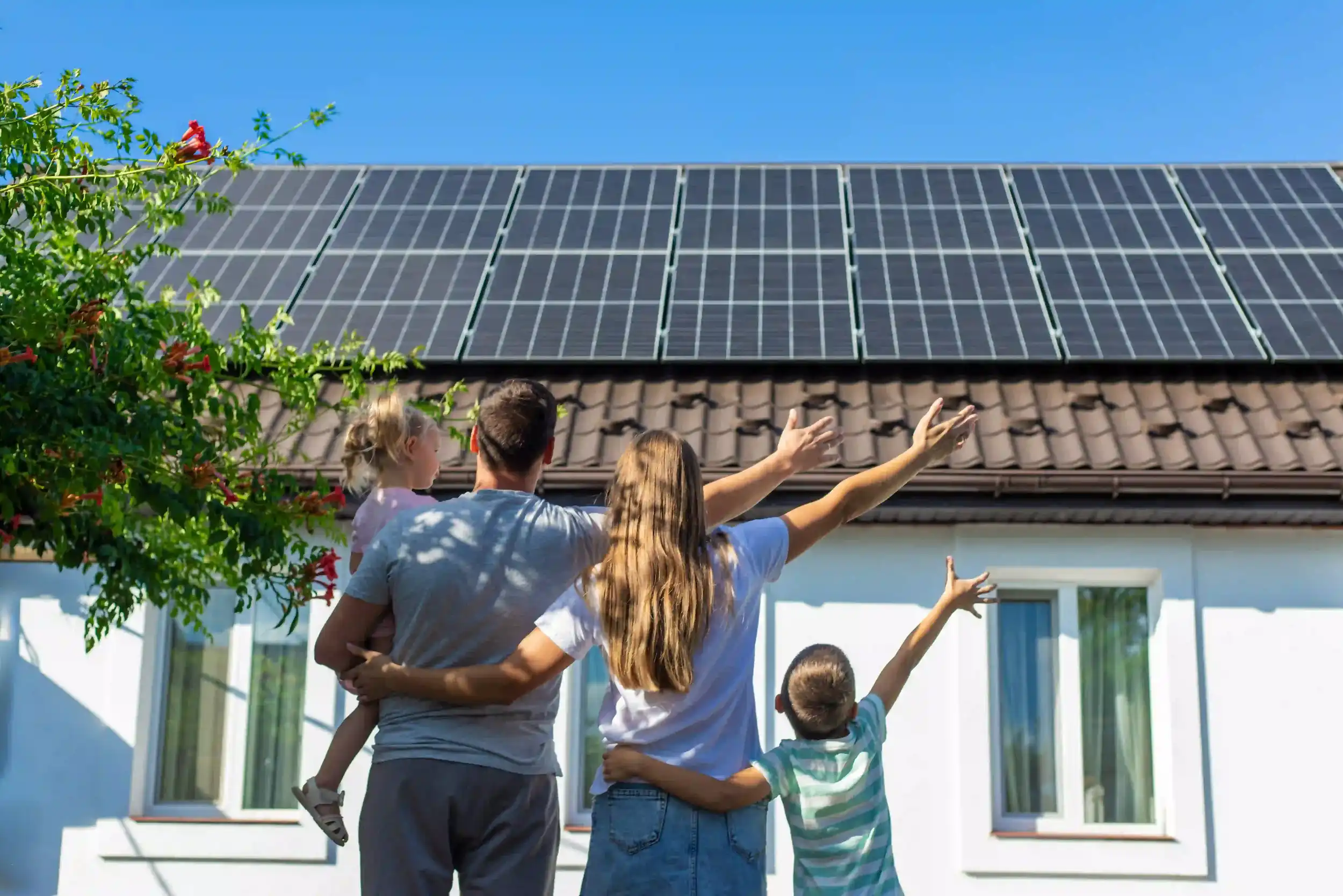 Family looking up at rooftop solar panels on their residential home in Rockhampton