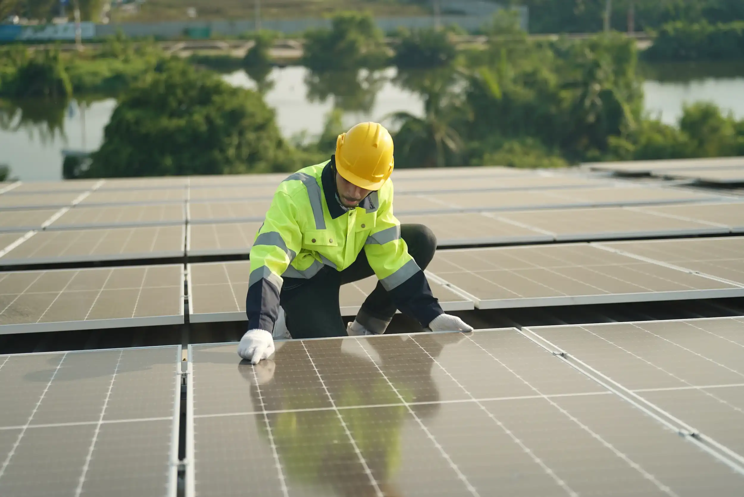 Solar technician installing panels on a warehouse roof for Queensland solar rebate eligibility