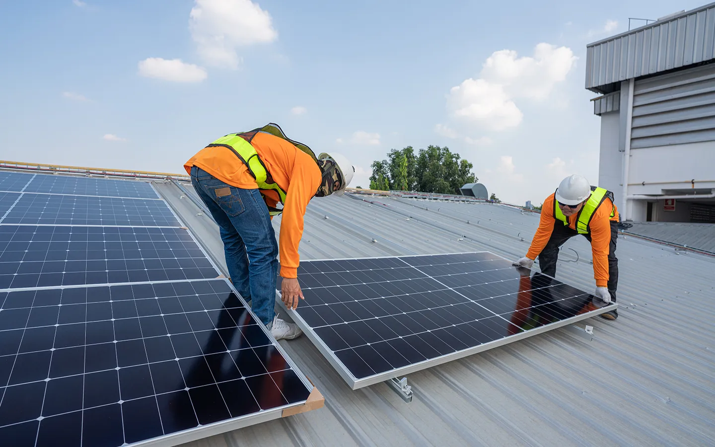 Solar installation experts positioning panels on a rooftop in Rockhampton.