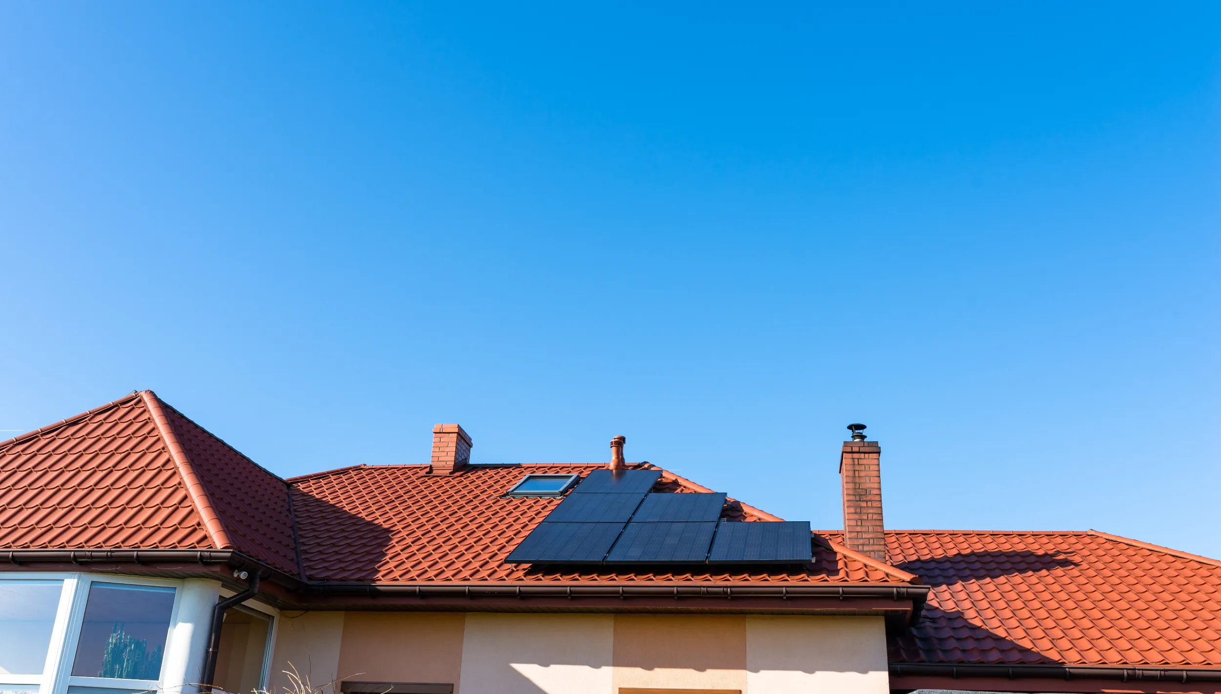 Residential rooftop solar panels installed on a coastal home in Keppel Sands, capturing clean energy under clear blue skies.