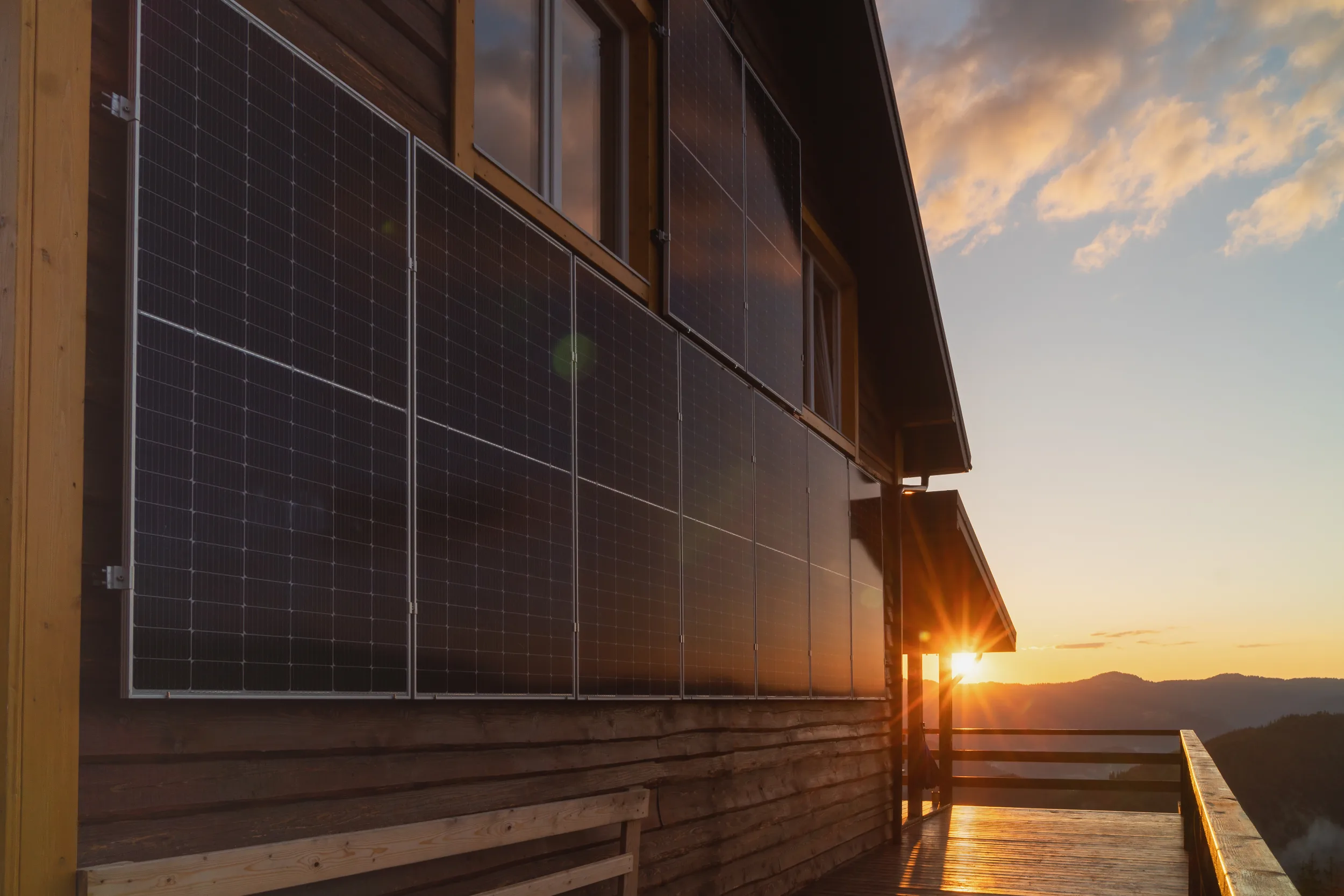 Building-integrated solar panels installed along the exterior wall of a modern home in Mount Morgan at golden hour.