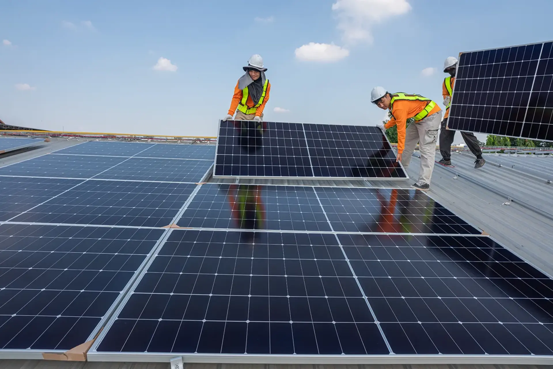 Technicians installing solar panels on a rooftop in Queensland
